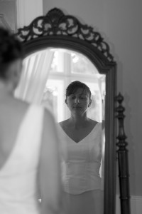 Photo of a girl in a dress looking at herself in a mirror