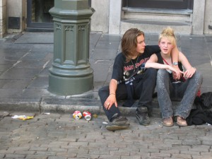 Photo of a teen couple sitting on sidewalk