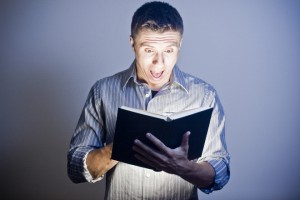 Photo of a man reading a glowing book -heading image for "What is the Best Study Bible Available?"