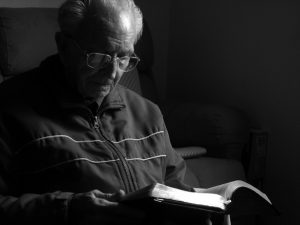 Photo of a man reading a Bible. Cover image for Myths About The Bible